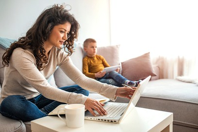 photo of woman working at home with kid
